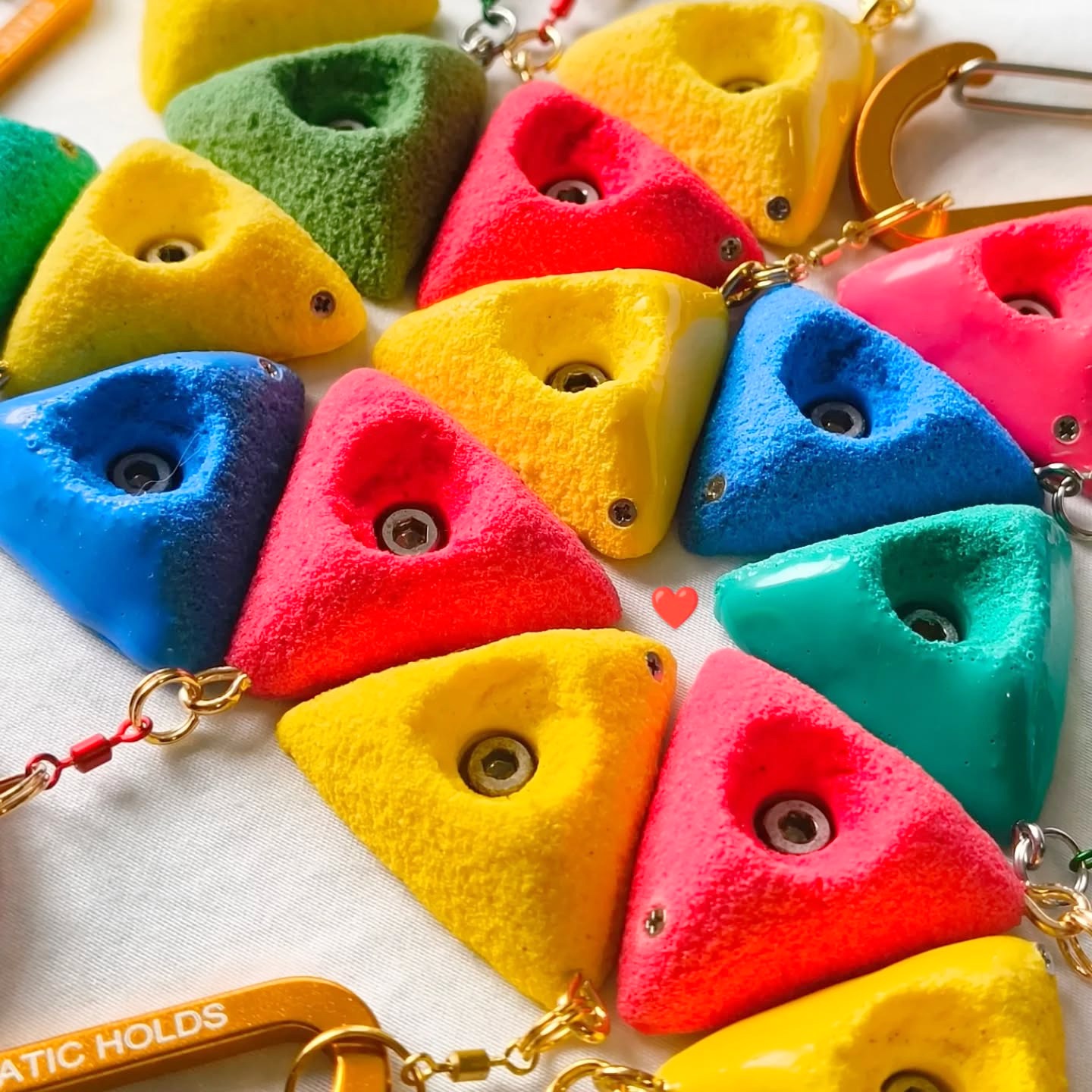 Bright triangular climbing hold keychains in assorted colours