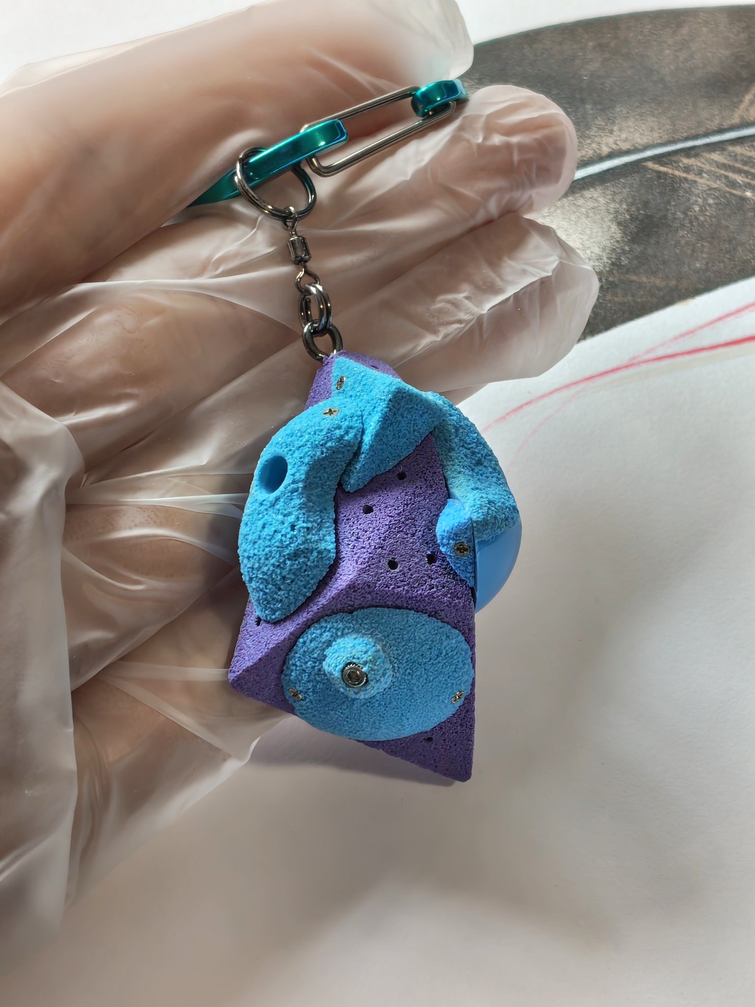 Purple and blue climbing volume keychain with teal carabiner
